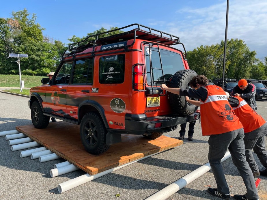 The challenge of pushing an old Land Rover on a platform.