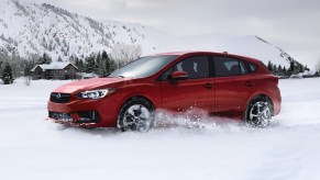 Red 2023 Subaru Impreza, the only new car with all-wheel drive costing under $20,000, driving in snow