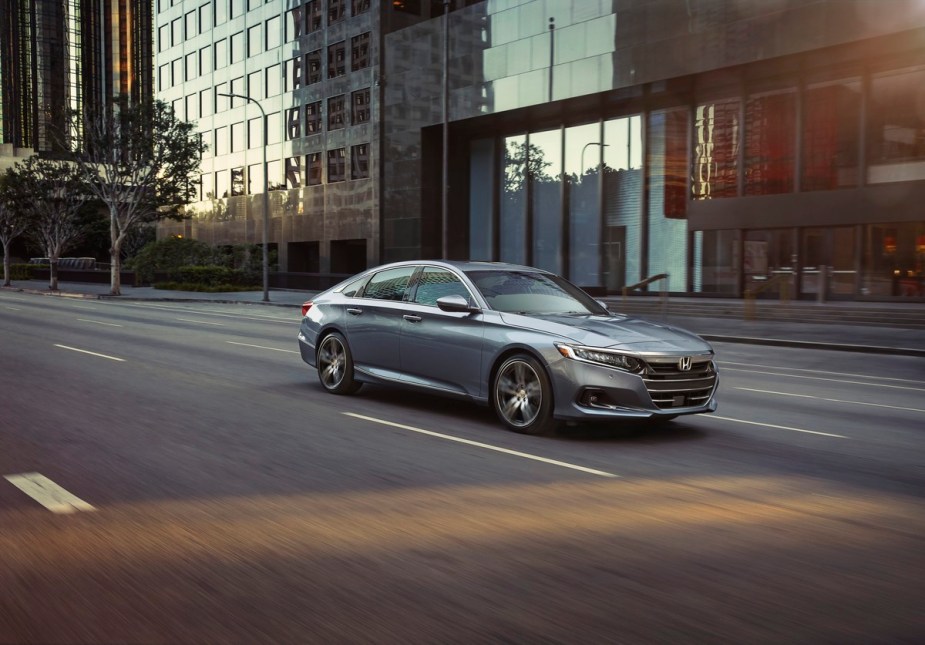 A silver Honda Accord Touring drives down a street.