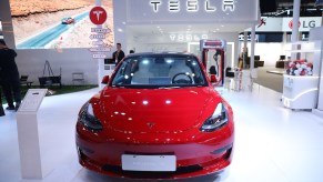 A red Tesla Model 3 parked indoors.