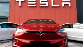 A Tesla dealership with Tesla's parked in front that potentially have Tesla's Full-Self Driving system.