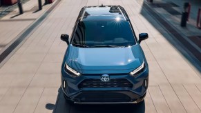 A blue 2022 Toyota RAV4 Hybrid small SUV is driving.