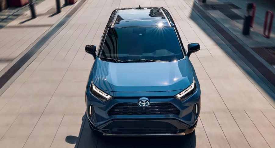 A blue 2022 Toyota RAV4 Hybrid small SUV is driving.