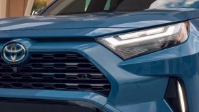 The front right of a blue Toyota RAV4 Hybrid small hybrid SUV.