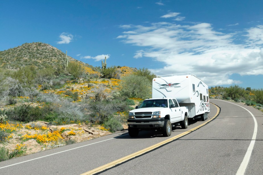 A truck capable of hauling ATVs, boats, and campers pulling a camper.