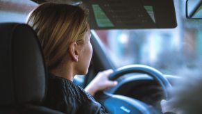 A young woman driving a car and following the rules of the road