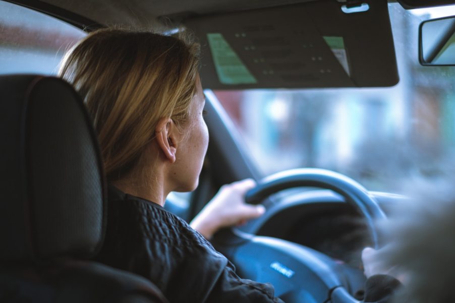 A young woman driving a car and following the rules of the road