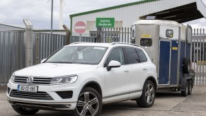 A white car towing a trailer.