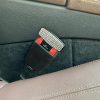 A picture of a seatbelt alarm stopper being used in place of a seatbelt.