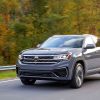 A gray 2022 Volkswagen Atlas Cross Sport premium two-row midsize SUV model driving on a forest highway road