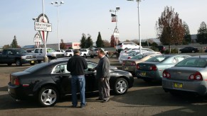 A car salesman talks to a customer about trading in a car.