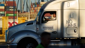 A truck driver driving in the sun.