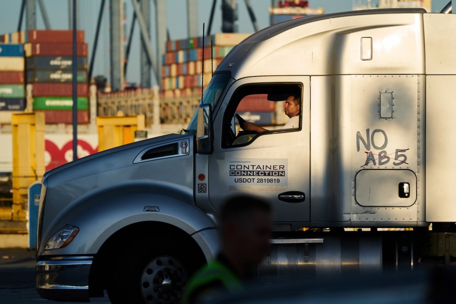 A truck driver driving in the sun. 