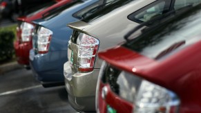 a lineup of used Toyota Prius hybrid cars on a dealer lot