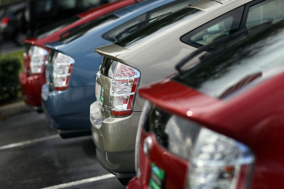 a lineup of used Toyota Prius hybrid cars on a dealer lot