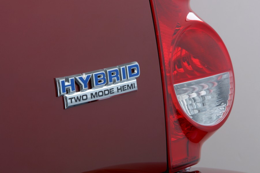 Closeup of a chrome "Hybrid Two Mode Hemi" badge on the rear of a red 2009 Dodge Durango full-size V8 SUV, one taillight visible as well.