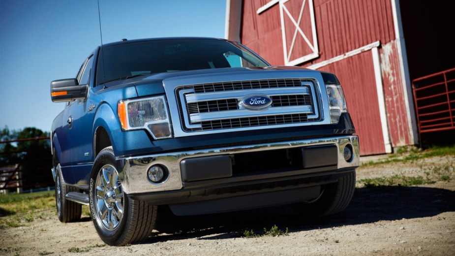 Blue 2013 Ford F-150 sitting next to a barn