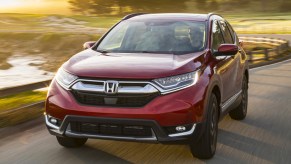 A red 2019 Honda CR-V is driving on the road.