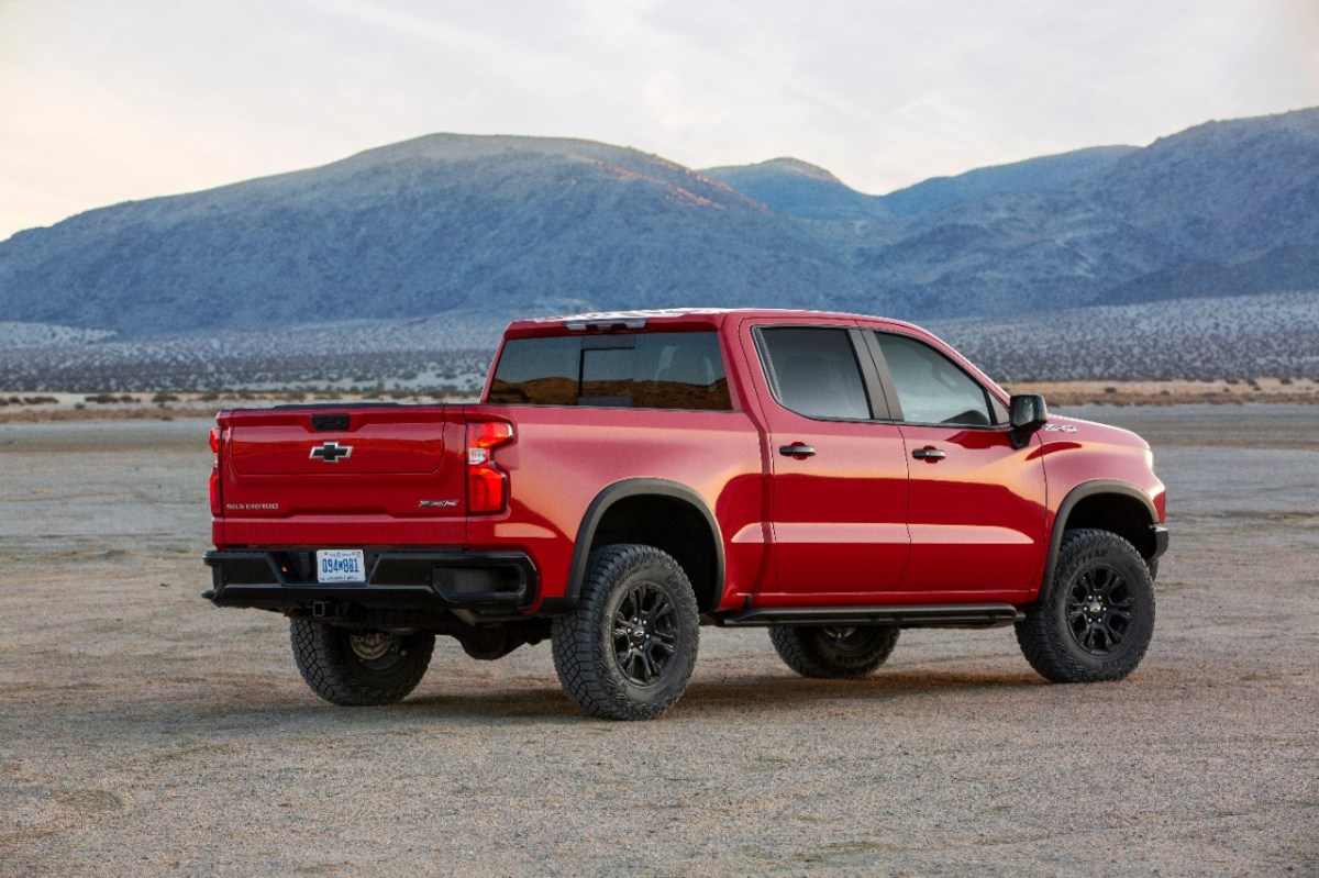 A red Chevy Silverado near a lake bed.