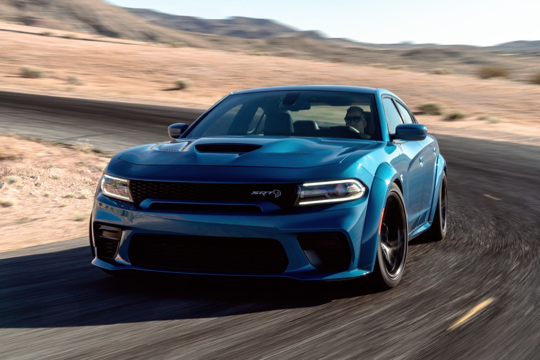 A blue 2022 Dodge Charger SRT Hellcat Redeye muscle car driving on a desert highway