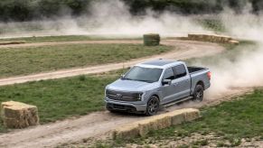 A gray 2022 Ford F-150 Lightning all-electric pickup truck model performing on a rally course