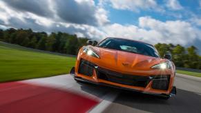 An orange 2023 Chevy Corvette Z06 takes a corner on the track.