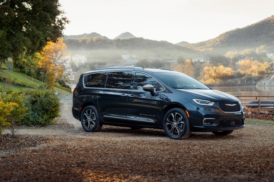 A dark 2023 Chrysler Pacifica PHEV parked in a fall scene.