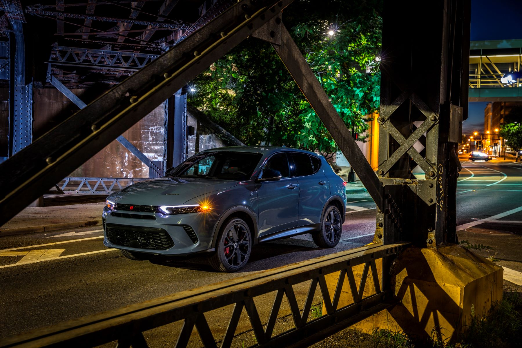 A gray 2023 Dodge Hornet GT compact plug-in hybrid electric vehicle (PHEV) SUV parked in a city