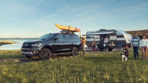 A blue 2023 Ford Expedition Max parked in front of a lake.