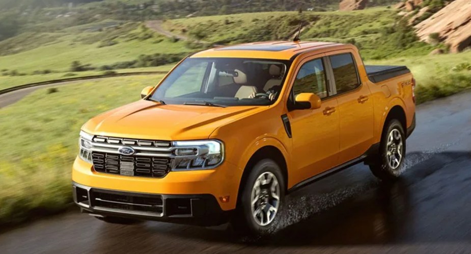 A yellow Ford Maverick small truck is driving on a wet road. 