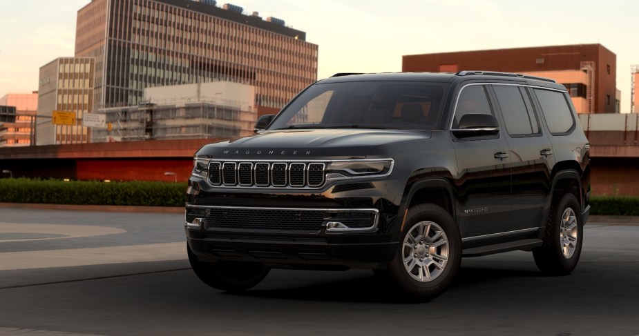 Promo photo of an entry-level Jeep Wagoneer Series I luxury SUV parked on a rooftop parking garage, a city skyline visible in the background.