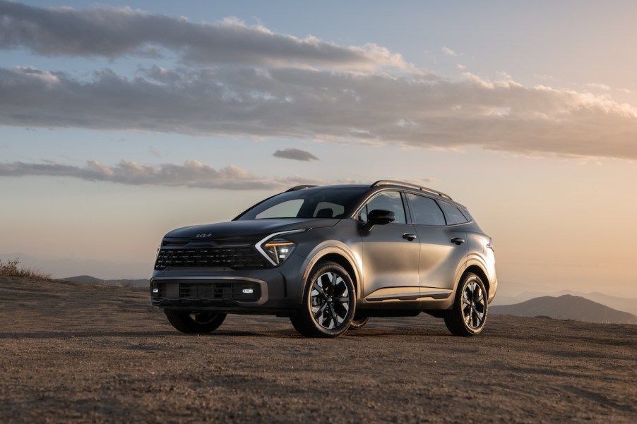 A silver 2023 Kia Sportage PHEV parked in an outdoor environment.