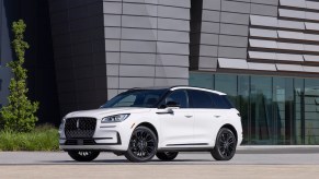 A white 2023 Lincoln Corsair parked in front of building.