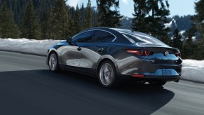 A light grey 2023 Mazda3 driving