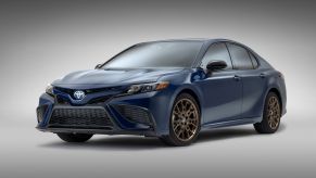 A promotional shot of a dark blue 2023 Toyota Camry midsize sedan