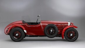 Painting of a red Alfa Romeo sports car from 11930, the first Gran Turismo (GT) from the factory.