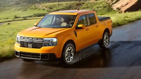 A yellow Ford Maverick is driving on a wet road.