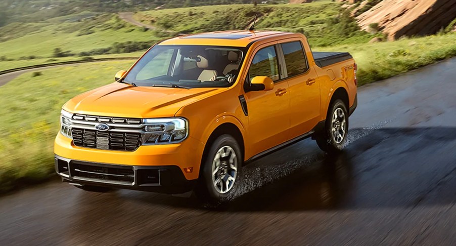 A yellow Ford Maverick is driving on a wet road.