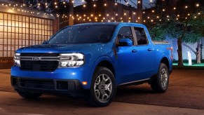 A blue Ford Maverick small pickup truck is parked outside.