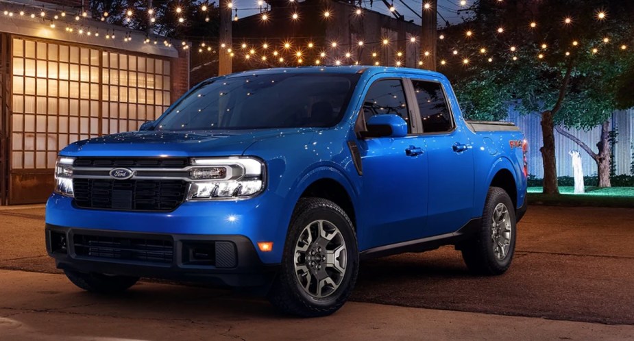 A blue Ford Maverick small pickup truck is parked outside. 