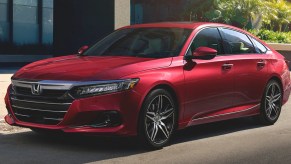 A red Honda Accord Hybrid midsize sedan is parked.