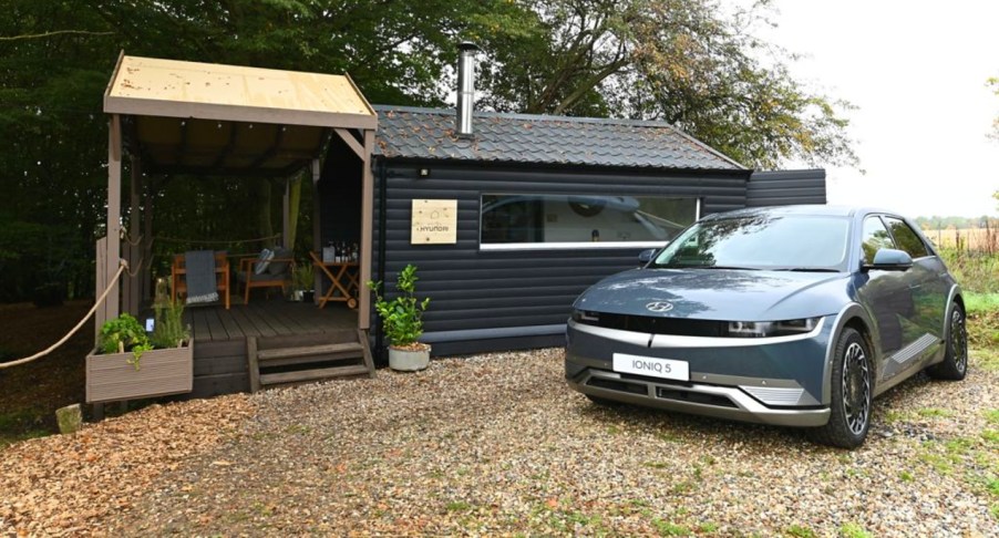 A blue Hyundai Ioniq 5 is parked outside Hotel Hyundai in Essex, England.