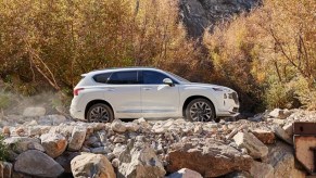 A white 2023 Hyundai Santa Fe midsize SUV is parked off-road.