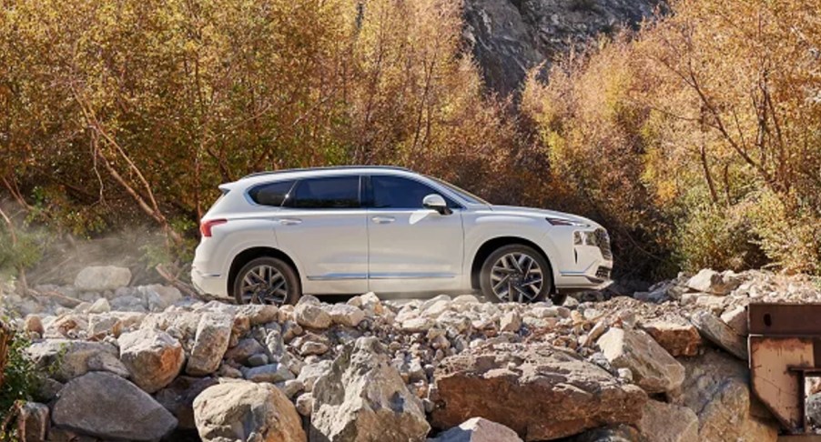 A white 2023 Hyundai Santa Fe midsize SUV is parked off-road.