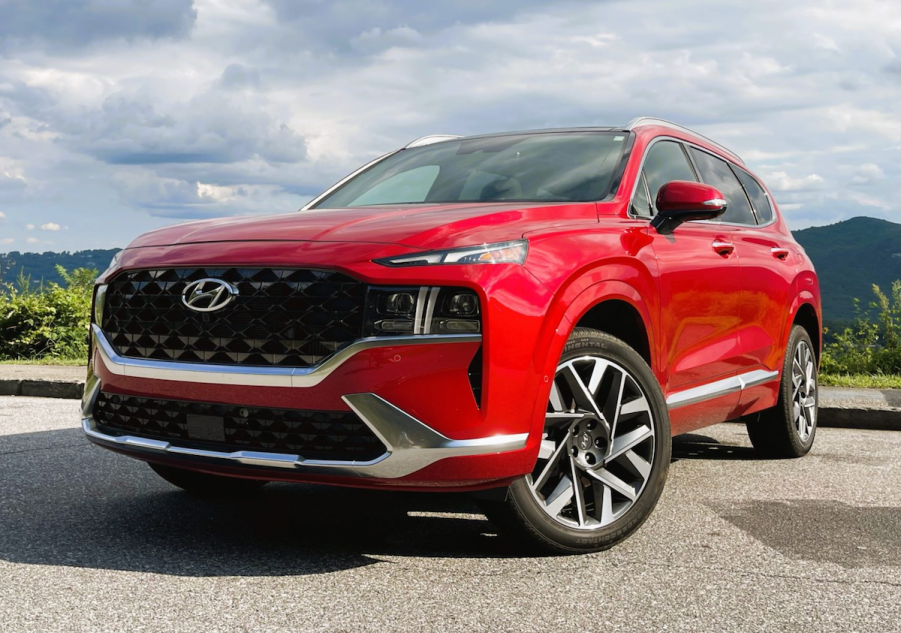 A red 2022 Hyundai Santa Fe parked on a scenic mountain road.