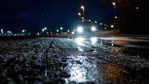 Ice covered road with headlights in the background, which is great for the best EVs for driving on ice and snow.