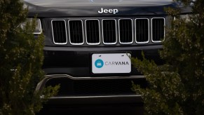 A Jeep's front grille is shown in close proximity with a Carvana logo as the license plate.