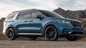 A blue 2023 Kia Carnival is parked outdoors.