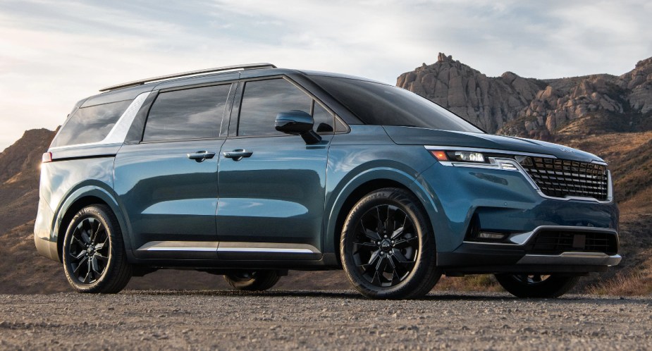 A blue 2023 Kia Carnival is parked outdoors.