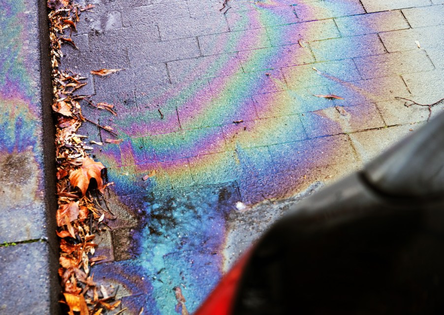 A rainbow oil stain from an oil leak where someone needs to clean up an oil spill.